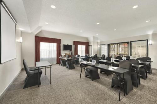 a conference room with tables and chairs and a screen at Country Inn & Suites by Radisson, Kansas City at Village West, KS in Kansas City