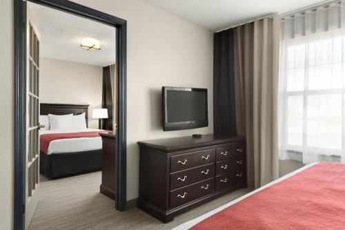 a hotel room with a bed and a television at Country Inn & Suites by Radisson, Kansas City at Village West, KS in Kansas City