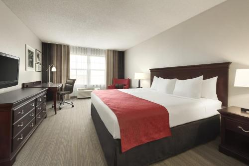 una camera d'albergo con un grande letto e una scrivania di Country Inn & Suites by Radisson, Kansas City at Village West, KS a Kansas City