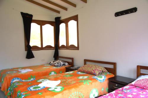 een slaapkamer met 2 bedden en een raam bij Hotel Internacional Jardín in Jardin