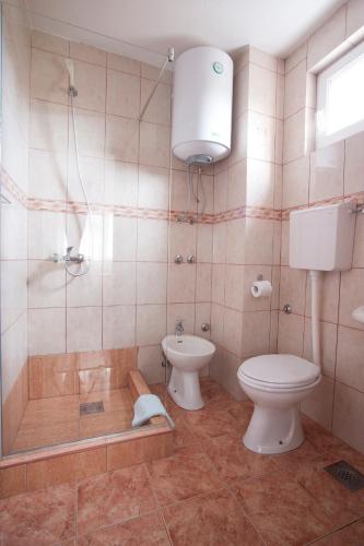 a bathroom with a shower and a toilet and a sink at Apartments Grand in Sveti Stefan