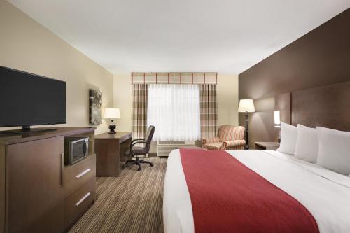 a hotel room with a bed and a flat screen tv at Country Inn & Suites by Radisson, Albert Lea, MN in Albert Lea