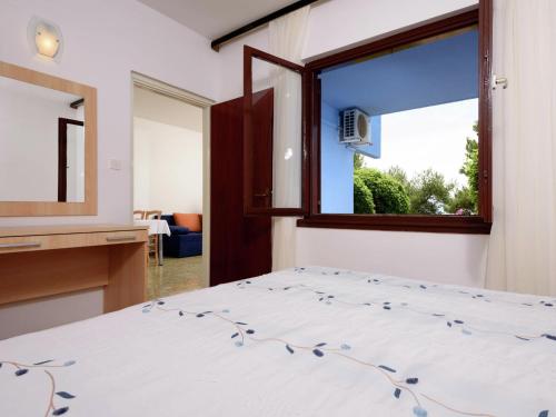 a bedroom with a bed and a window at Apartment Medena in Trogir