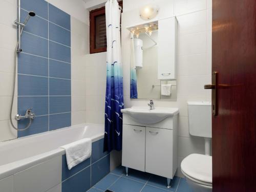 a bathroom with a toilet and a sink and a tub at Apartment Medena in Trogir