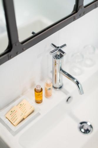 un lavabo de salle de bain avec un distributeur de savon dessus dans l'établissement Hotel So’Co by Happyculture, à Nice