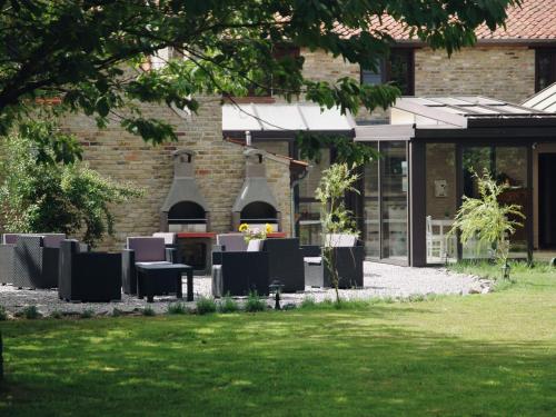 patio ze stołami i krzesłami przed budynkiem w obiekcie Luxurious Holiday Home with Sauna in Alveringem w mieście Leisele