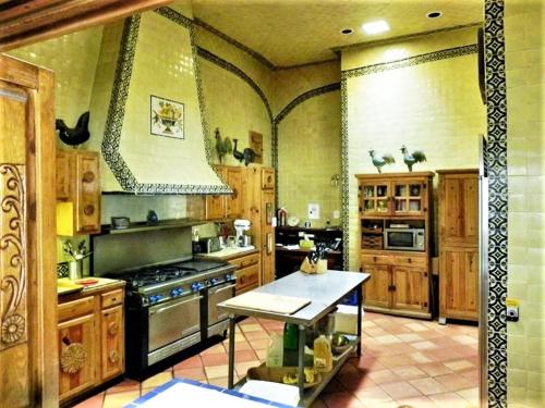 a large kitchen with wooden cabinets and a stove at Casa Benavides Inn in Taos