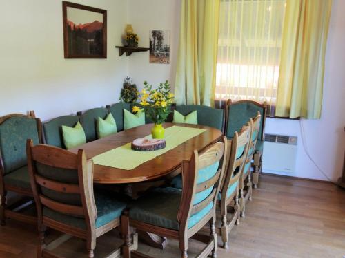 uma sala de jantar com uma mesa de madeira e cadeiras em Holiday apartment in Ferlach near Woerthersee em Oreinschnak