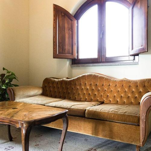 a brown couch in a living room with a window at De Vita Beata Agriturismo in Veroli