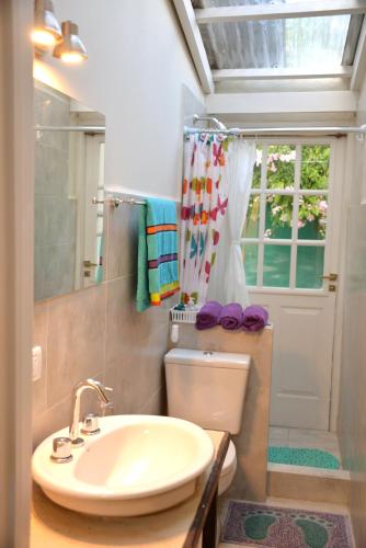 a bathroom with a sink and a toilet and a mirror at Loft Urbano in Tandil