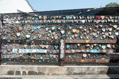 a wooden fence covered in lots of different types of hearts at Sea View Holiday House in Hong Kong