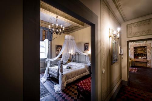 a bedroom with a bed with a canopy at Palazzo Petrella in Cortona