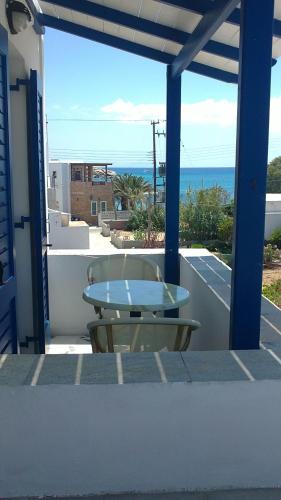 a table on a balcony with a view of the ocean at Flora Apartments & Studios in Agia Anna Naxos