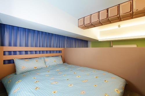 a bedroom with a bed with a blue wall at Jack Castle in Tainan