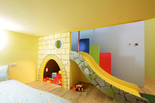 a childs bedroom with a bunk bed and a play house at Jack Castle in Tainan