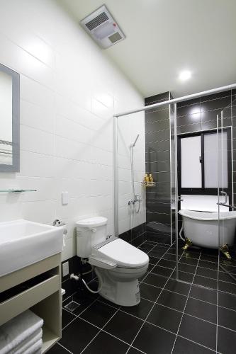 a bathroom with a toilet and a sink and a tub at Jack Castle in Tainan