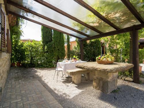 patio z kamiennym stołem i drewnianą pergolą w obiekcie Holiday home in Cortona with pool w mieście Cortona