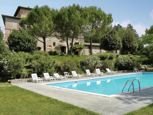 Una piscina con tumbonas y una casa. en Apartment in Umbria near Lake Trasimeno, en Mantignana