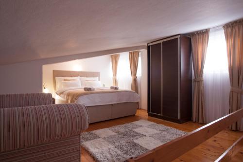 a bedroom with a bed and a couch at Apartments Grand in Sveti Stefan
