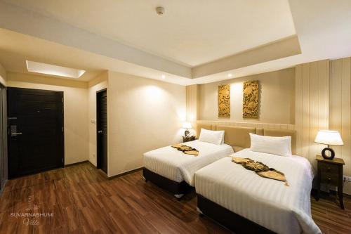 a hotel room with two beds with white sheets at Suvarnabhumi Ville Airport Hotel in Lat Krabang