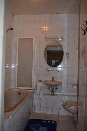 a bathroom with a tub and a sink and a bath tub at Hotel De Spiegel in Sint-Niklaas