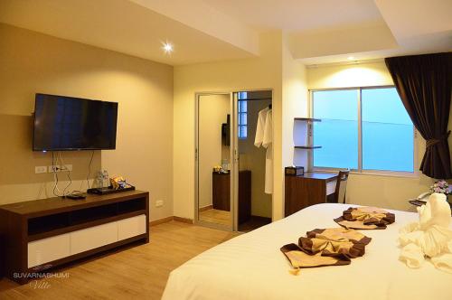 a hotel room with a bed and a television at Suvarnabhumi Ville Airport Hotel in Lat Krabang