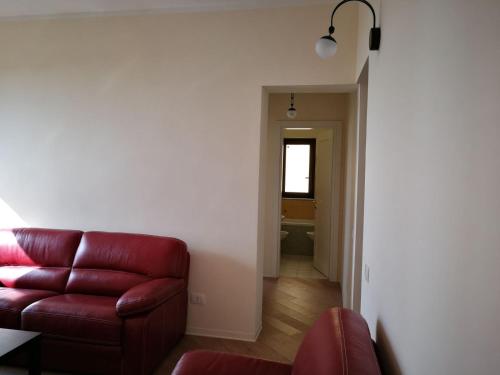 a living room with a red couch and a hallway at Backpackers in Agrigento