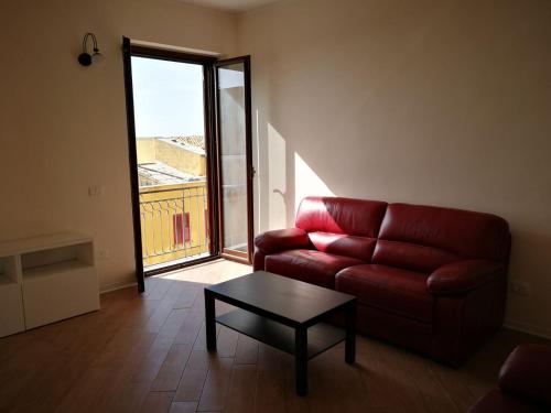 a living room with a red couch and a table at Backpackers in Agrigento