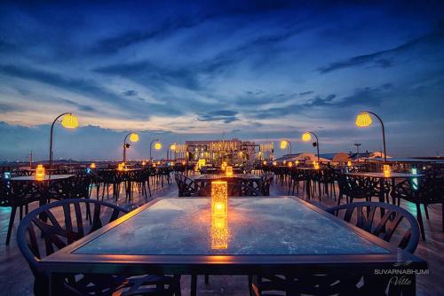 a table with chairs and lights on a beach at Suvarnabhumi Ville Airport Hotel in Lat Krabang