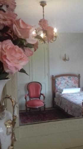 a room with a mirror and a chair and a bed at Manoir de Sens in Beuvron-en-Auge