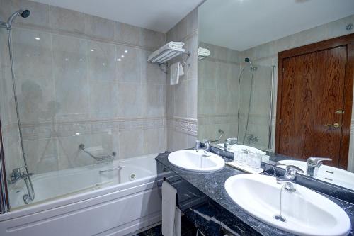 a bathroom with two sinks and a bath tub at Hotel Vila-real Palace in Villareal