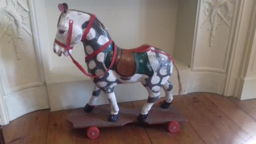 a plastic horse on a skateboard on the floor at Manoir de Sens in Beuvron-en-Auge