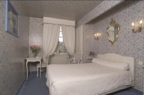 エクス・アン・プロヴァンスにあるHôtel le Prieuréのベッドルーム1室(白いベッド1台、テーブル、窓付)
