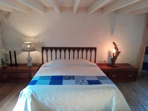 Schlafzimmer mit einem großen Bett mit blauer und weißer Bettwäsche in der Unterkunft La Motelle N 5 in Les Ulmes
