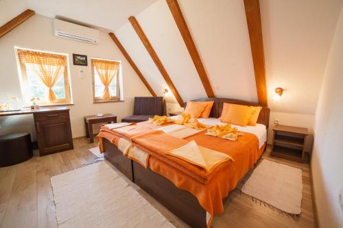 una camera da letto con un grande letto con lenzuola arancioni di Guest House Rustico a Korenica
