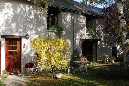 a white house with a table and a door at Le Relais de la Tour in La Chaussée-Saint-Victor