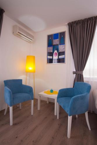 a room with two blue chairs and a table at Apartments Grand in Sveti Stefan