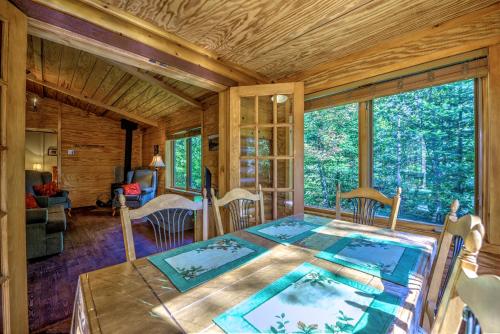 a room with a table and a large window at Le Grand R in Saint-Donat-de-Montcalm