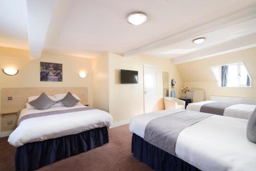 a hotel room with two beds and a television at The Lanes Hotel in Brighton & Hove