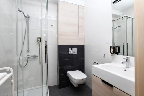 uma casa de banho com um chuveiro, um WC e um lavatório. em Apartament Katarzynki em Gdansk
