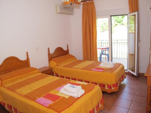 ein Hotelzimmer mit 2 Betten und einem Balkon in der Unterkunft Apartamentos Rurales El Pinar in Coto Rios