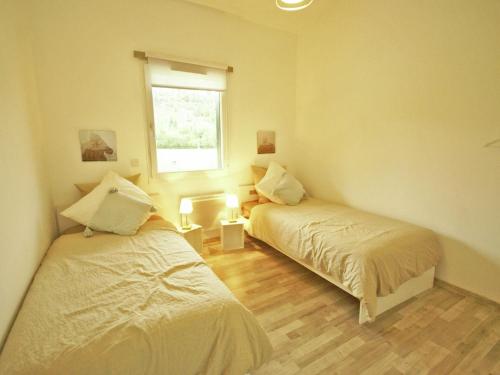 a bedroom with two beds and a window at Comfortable apartment with balcony in Abreschviller