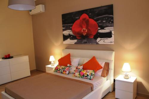 una camera da letto con un letto con un fiore rosso sul muro di Tortugas B&B a Giarre