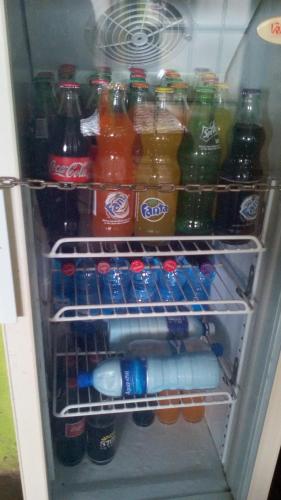 an open refrigerator filled with drinks and sodas at Mona Lisa Guest House, Kisumu in Kisumu