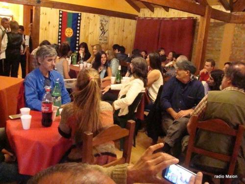 a group of people sitting at tables in a room at El hostel secreto in Lago Puelo