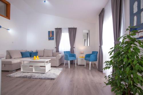 a living room with a couch and blue chairs at Apartments Grand in Sveti Stefan