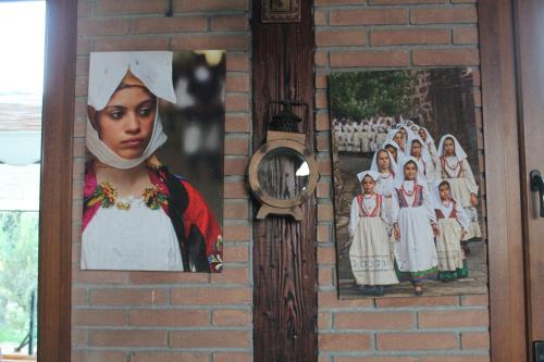 a wall with two pictures of nuns and a clock at Agriturismo Su Recreu in Ittiri