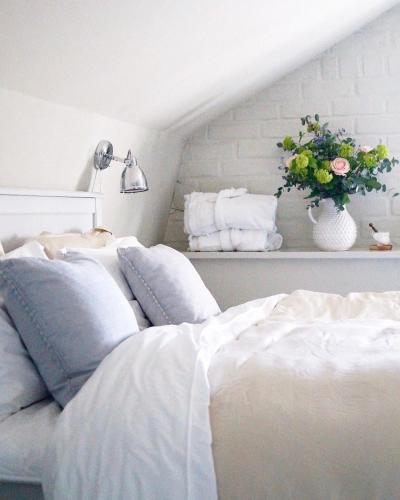 a bedroom with a white bed and a vase of flowers at Fredriksborg Hotell & Restaurang in Värmdö
