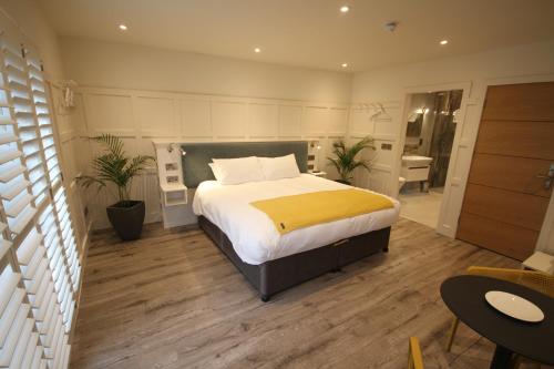 a bedroom with a large bed with a yellow blanket at Quinlan & Cooke Boutique Townhouse and QCs Seafood Restaurant in Cahersiveen