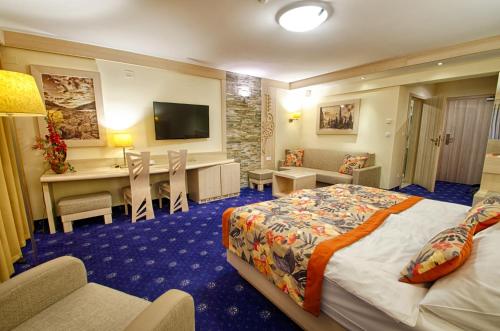 a hotel room with a bed and a desk at Hotel Toporów in Białka Tatrzanska